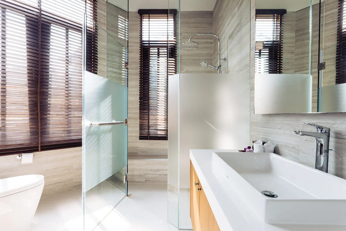 An ensuite bathroom with twin basins, a rain shower and timber shutters