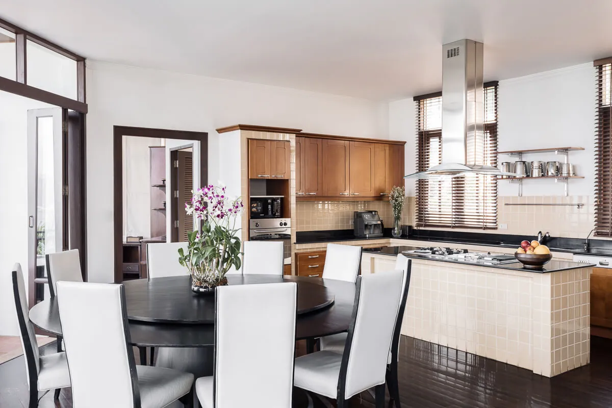 The open-plan chef's kitchen at Villa Baan Paradise with its island bench and the indoor dining table