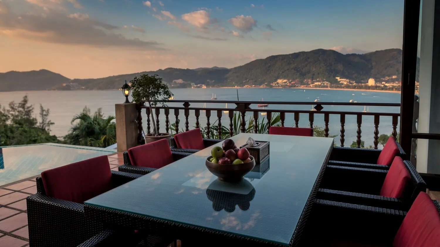 The outdoor dining table on the terrace at dusk, set above Patong Bay