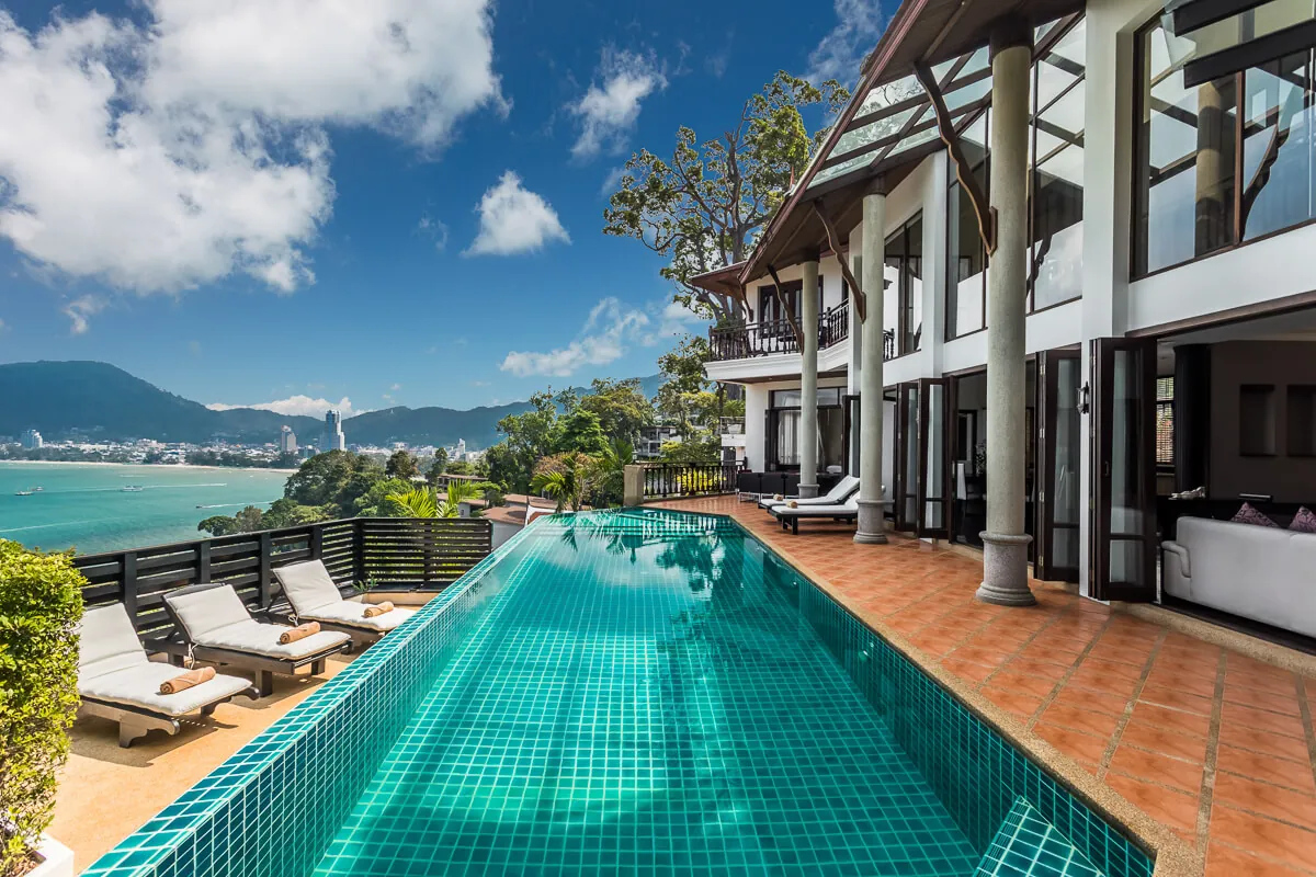 The full length of the 14 metre infinity pool at Villa Baan Paradise, the villa on one side and the hills of Patong beyond