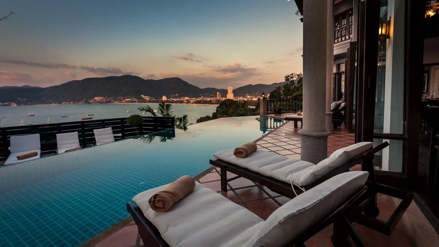 Sunset from the pool terrace at Villa Baan Paradise, looking across the infinity edge to Patong and the Andaman Sea